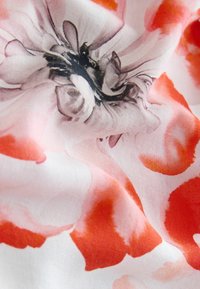 Stof med blomstermønster i lyserøde og orange nuancer med en glat tekstur. Designet inkluderer abstrakte blomsterformer og bløde gradients.