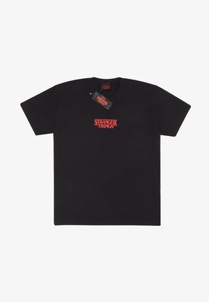 Černé bavlněné tričko s červeným logem "STRANGER THINGS" napříč hrudníkem v tučném, stylizovaném písmu. Krátké rukávy a kulatý výstřih.