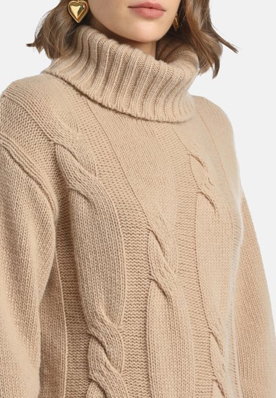 Pulover bej tricotat cu guler înalt cu nervuri groase, având modele de tricotaj în cablu și un finisaj texturat.