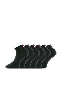 Chaussettes noires en coton à chevilles avec des bordures côtelées, arborant un petit logo rouge et blanc. Six paires disposées en rang, texture lisse.