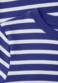Nahaufnahme eines blauen und weißen, horizontal gestreiften Baumwollstoffs mit genähtem rundem Halsausschnitt und Schulternaht.
