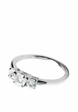 Anillo de plata con tres piedras preciosas redondas y transparentes colocadas en fila sobre una banda lisa, mostrado sobre un fondo blanco.