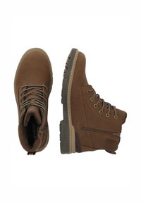 Bottines en cuir marron avec bout rond, laçage à l'avant, semelle en caoutchouc, fermeture éclair sur le côté et accents texturés sur le talon et la languette.