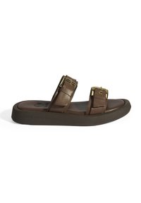 Sandale en cuir brun à glisser avec deux larges sangles, accents en matériel doré et une semelle noire robuste. Texture lisse et design minimaliste.