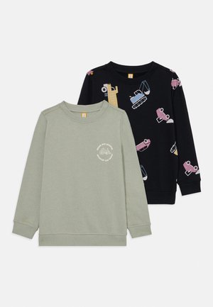 Zwei langärmelige Kinderpullover mit Rundhalsausschnitt, einer hellgrün mit kleinem Traktoraufdruck, der andere schwarz mit einem bunten Muster aus Baustellenfahrzeugen.