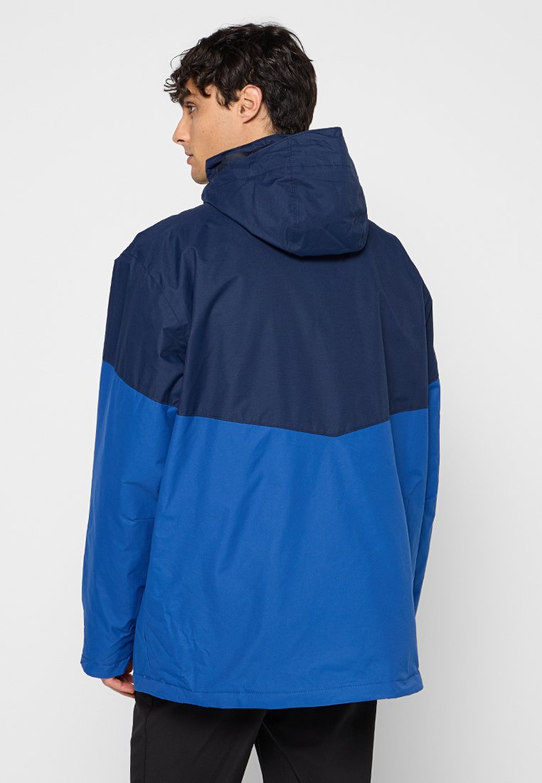 Blauwe en donkerblauwe waterdichte jas met capuchon, voorzien van een driehoekig kleurblokdesign, een soepele textuur en een relaxte pasvorm.