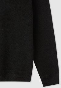 Czarny sweter z dzianiny z teksturowanym wykończeniem, prążkowymi mankietami i dołem, o luźnym kroju, pokazany z perspektywy rękawa i dolnej części ciała.