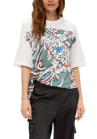 Losse, korte mouw top met een groen bloemenpatroon en rode, blauwe en witte accenten. De textuur van de stof contrasteert met de witte mouwen.
