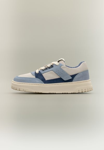 Baskets basses en cuir suédé crème, bleu clair et marine avec des lacets blancs et une semelle épaisse en caoutchouc blanc cassé.