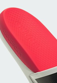 Rød Adidas Cloudfoam slide sandal sål med tekstureret greb og præget branding på den røde fodseng og siden.