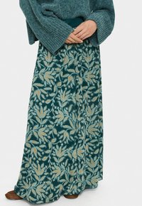 Maxi nederdel med en mørk teal baggrund, der har guld- og lysblå blomster mønstre. Blødt stof med et let design og elastisk talje.