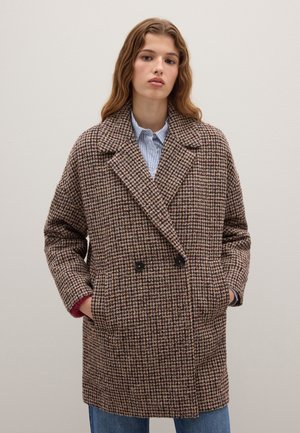 Cappotto doppiopetto in un motivo a scacchi marrone e crema, dotato di ampi revers e tasche laterali, con un interno foderato.