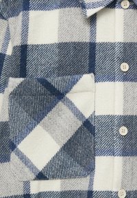 Camicia a quadri blu e grigia realizzata in tessuto testurizzato, con taschino sul petto, chiusura con bottoni e bottoni di colore chiaro.