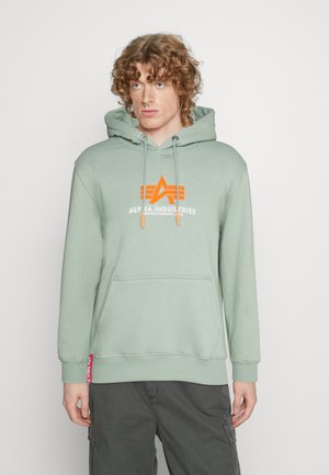 Sudadera verde menta hecha de suave algodón, con un logo naranja, bolsillo frontal y capucha ajustable con cordón. Puños y dobladillo acanalados.