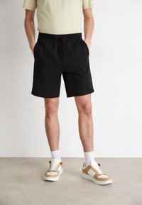 Calvin Klein Jeans LOGO REPEAT - Pantalones deportivos - black