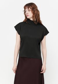 Top nero a maniche corte con collo alto, realizzato in tessuto liscio; presenta una vestibilità comoda e leggere svasature sulle spalle.
