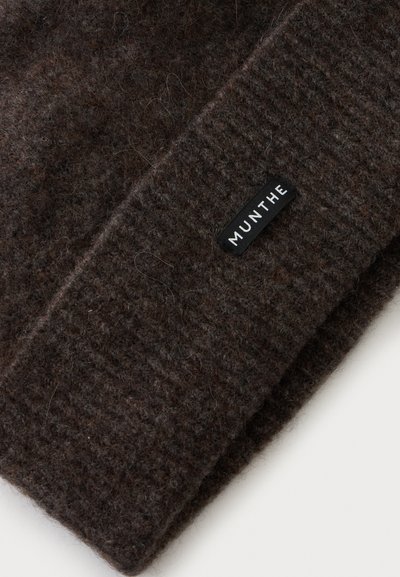 Écharpe en laine tricotée brun foncé avec une étiquette de marque MUNTHE tissée cousue à une extrémité.