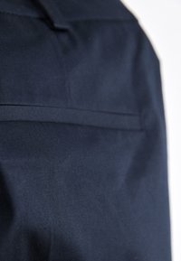 Navy fabric with a smooth texture, featuring a horizontal seam and minimalistic design. No additional accents or patterns visible.