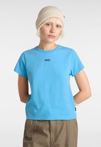 Sininen puuvillainen t-paita lyhyillä hihoilla ja pyöreällä kaula-aukolla. Rintataskussa musta "VANS" -logo ja rento leikkaus.