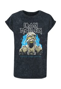 Sort t-shirt med korte ærmer og en slidt finish. Har et grafik af en skeletfigur i kæder, med blå detaljer og informationer om turnéen.