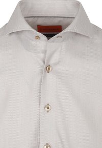 Lichtgrijs patroonhemd met een gestructureerde stof, voorzien van een spread collar en zes ronde, beige knopen aan de voorkant.