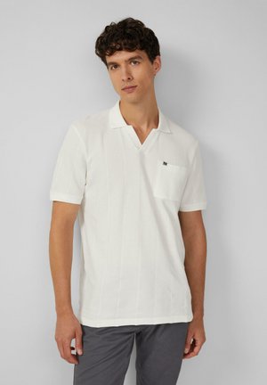 Witte polo met korte mouwen en een v-hals, voorzien van textuurstrepen en een borstzak. Draag je met grijze broek.