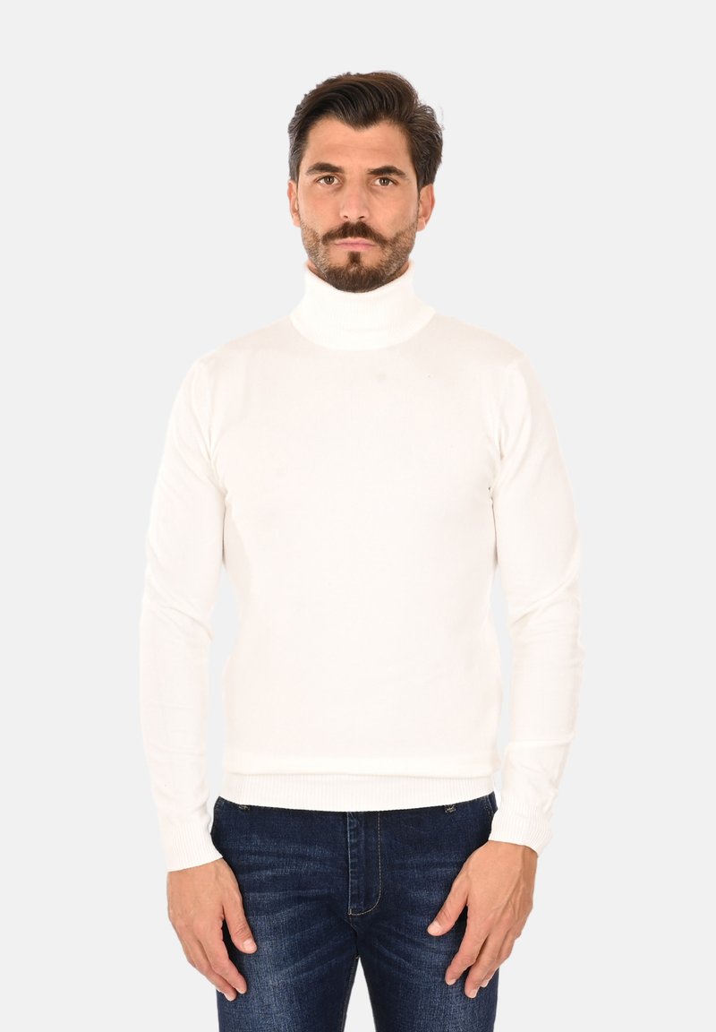 Maglione bianco a collo alto con un design aderente, realizzato in un tessuto morbido con polsini e orlo a coste, abbinato a jeans blu scuro.