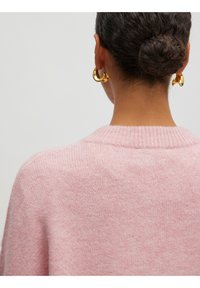 Helles rosa gestricktes Sweatshirt mit einem gerippten Kragen, das eine weiche Textur aufweist. Das Design zeichnet sich durch einen lockeren Schnitt und klare Linien auf der Rückseite aus.