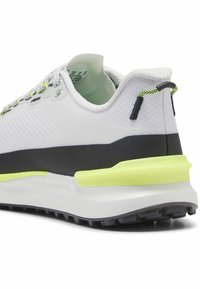 Bela atletska čevlja z mrežasto zgornjim delom in črnim podplatom. Ima svetlo rumen poudarek na peti in teksturiran podplat za oprijem.