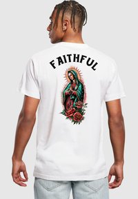 Witte katoenen t-shirt met een levendig geprinte afbeelding op de rug, die een figuur toont omringd door rode rozen, met het woord "FAITHFUL" erboven.
