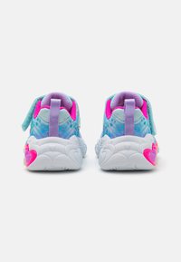 Helles blaues Sportschuh-Modell mit einem gemusterten Obermaterial, lila Akzenten und rosa Herzdetails auf der weißen Sohle. Klettverschluss für die Befestigung.