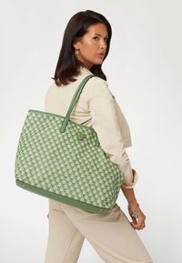 Borsa tote a quadri verdi con motivo testurizzato, dotata di manici e dettagli in pelle verde. Realizzata in materiale durevole.