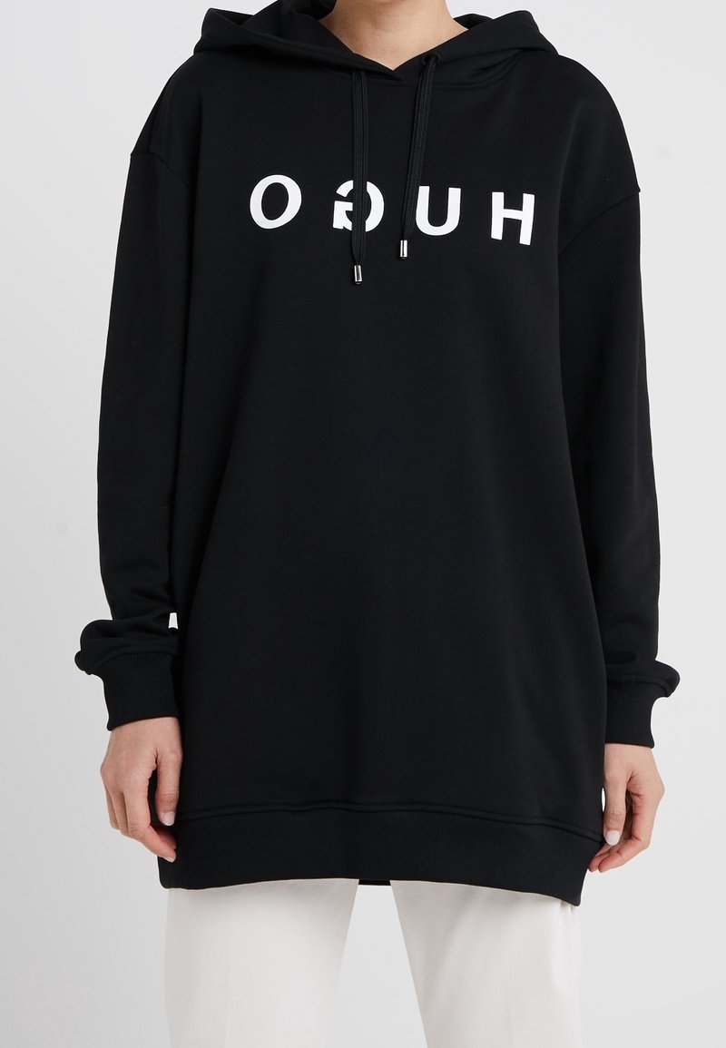 Sweat à capuche noir à coupe ample, avec un texte graphique blanc imprimé sur le devant, des poignets côtelés et des cordons de serrage à embouts métalliques.