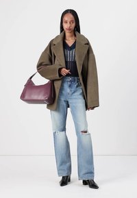 Abrigo oversized verde oliva, blusa de rayas azul marino, jeans desgastados de color azul claro, bolso burdeos, botas negras de punta; texturas suaves y ajuste relajado.