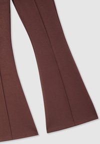 Leggings marroni a zampa d'elefante realizzati in tessuto morbido, caratterizzati da una superficie liscia e cuciture ben definite lungo le gambe, con un delicato motivo melange.