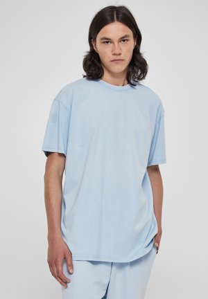 Light blue oversized t-shirt made of soft cotton, featuring a round neckline and short sleeves. Smooth texture and minimalistic design.