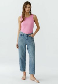 Ribbed pink tank top, high-waisted light blue jeans with straight legs, and clear strap sandals. Simple design with functional pockets.