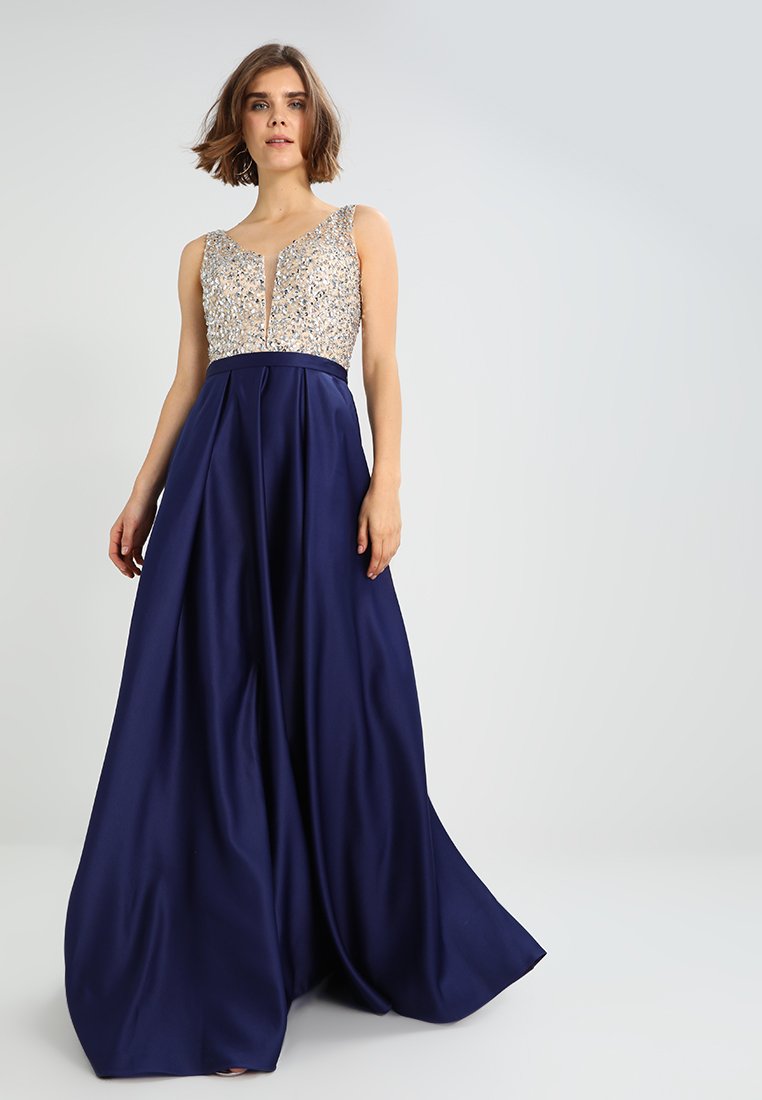 Długa granatowa suknia z dopasowanym gorsetem ozdobionym skomplikowanymi srebrnymi koralikami. Posiada głęboki dekolt w serek oraz zwiewną, plisowaną spódnicę.