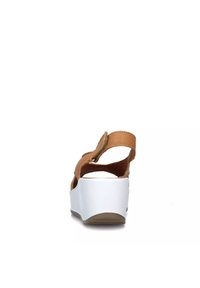 Sandalo in pelle marrone con cinturino regolabile, tacco a zeppa bianco e suola texture, visto da dietro.