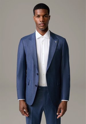Marineblauer Anzug mit strukturiertem Finish, ausgestattet mit einem spitzen Revers, doppelten Knöpfen und einem frischen weißen Hemd darunter.