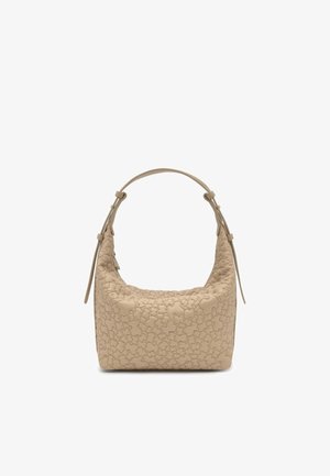 Beżowa torebka z fakturowanym pikowaniem w kwiaty i regulowanym paskiem na ramię, prezentowana na białym tle.