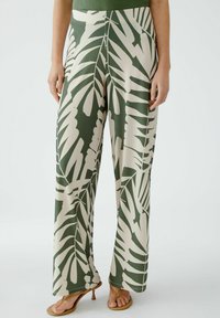 Grüne und beige gemusterte weite Hosen mit einem Blattdesign, aus glattem Stoff, mit einem elastischen Bund und einer lockeren Passform.