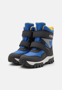 Bottes d'hiver pour enfants bleu et noir avec doublure jaune, bandes Velcro, semelles robustes et tissu imperméable pour un usage en extérieur.