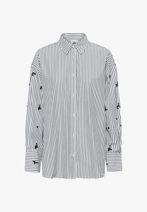 Camisa de botones a rayas en blanco y negro, con mangas largas y detalles bordados en negro. Confeccionada en una tela ligera.