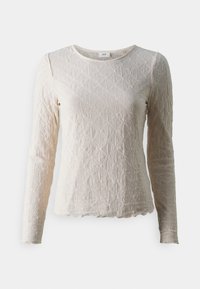 Světle béžový dlouhý rukáv top s texturovaným diamantovým vzorem, kulatým výstřihem a vlnkovaným lemem. Vyrobeno z měkké, prodyšné látky.
