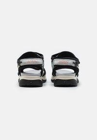 Black and grey sandals with adjustable straps, textured upper material, cushioned footbed, and a durable black rubber sole.
