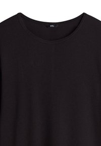 Chemise noire à manches longues côtelée avec un col rond. Le tissu semble doux et texturé avec une légère élasticité. Étiquette de la marque visible.