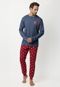 Camisa de manga larga azul con gráfico rojo "NOPE NOT TODAY", combinada con pantalones de pijama rojos que presentan un patrón de muñecos de nieve en blanco y azul.