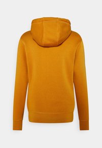 Felpa arancione con cappuccio, realizzata in un tessuto morbido, dotata di tasca a marsupio e polsini a costine. La vista posteriore evidenzia il dettaglio della cucitura del cappuccio.