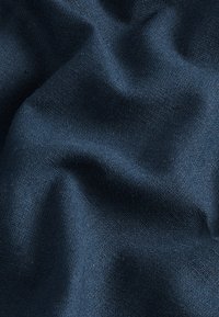 Donkerblauwe gestructureerde stof met zichtbare knopen en plooien, gemaakt van een zacht, geweven materiaal, met een gelijkmatige kleurverdeling en zonder patronen.